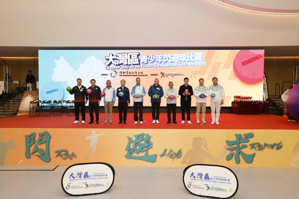 （左起）闪避球总会理事会顾问李庆年、闪避球总会会长李一、跨部门反恐专责组主管梁伟基、中联办宣传文体部体育处处长朱剑平、警务处副处长(行动) 叶云龙、保安局副局长卓考业、北优青荣誉顾问严玉麟、立法会议员谭镇国、北优青主席林以律、北优青会长苏家俊，为大湾区交流赛主持开球仪式。