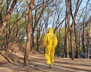 李迪“穿防护衣载防毒面罩”行走在校园。
