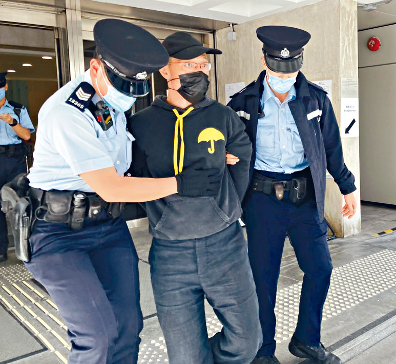 穿黃雨傘圖樣黑色衞衣男子，由警員帶走。