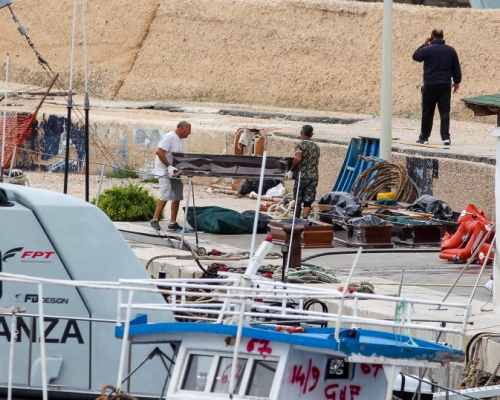 意大利南部一艘怀疑载著非法移民的船只沉没，救援人员将死者遗体送到岸上。AP