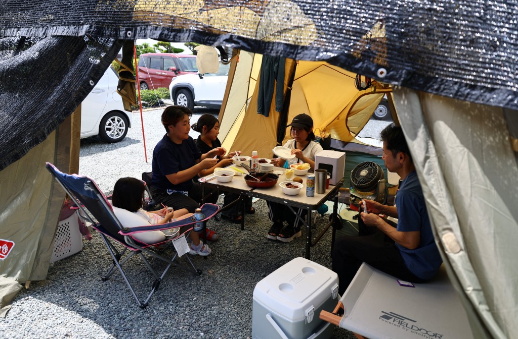 地震後不敢住在屋內，八代市46歲的島田弘介和家人在自家門前的帳篷裡吃午飯。路透社
