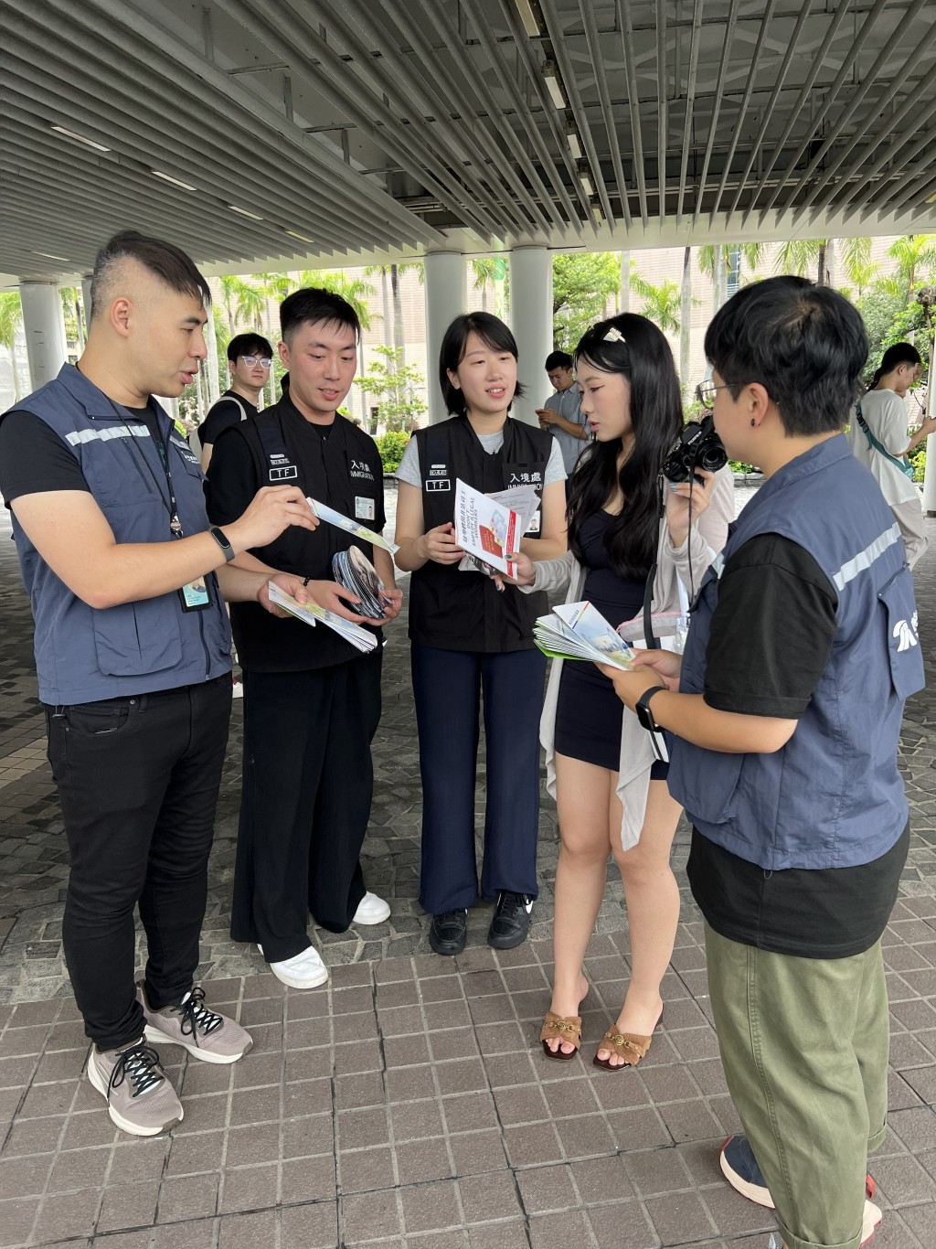 入境處及旅監局人員向市民及旅客派發宣傳單張，呼籲切勿聘用非法領隊或導遊。入境處圖片