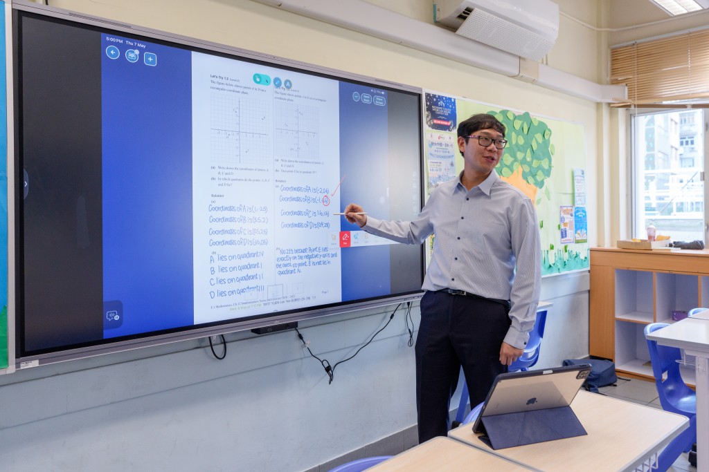 黃偉業主任指新添置的人工智能互動電子白板能大幅增加學生在課堂上的參與度與互動。