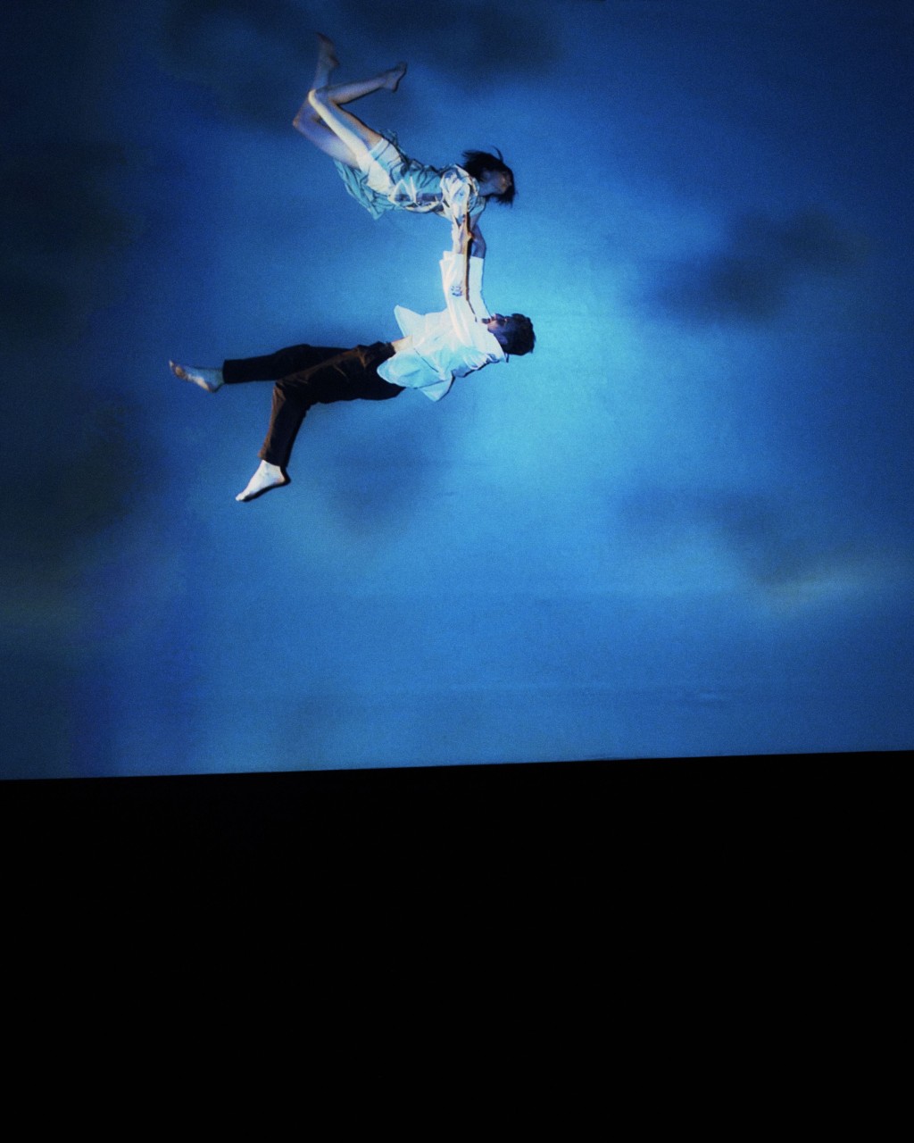 饰演情侣的舞者在蓝色空中表演现场舞蹈。