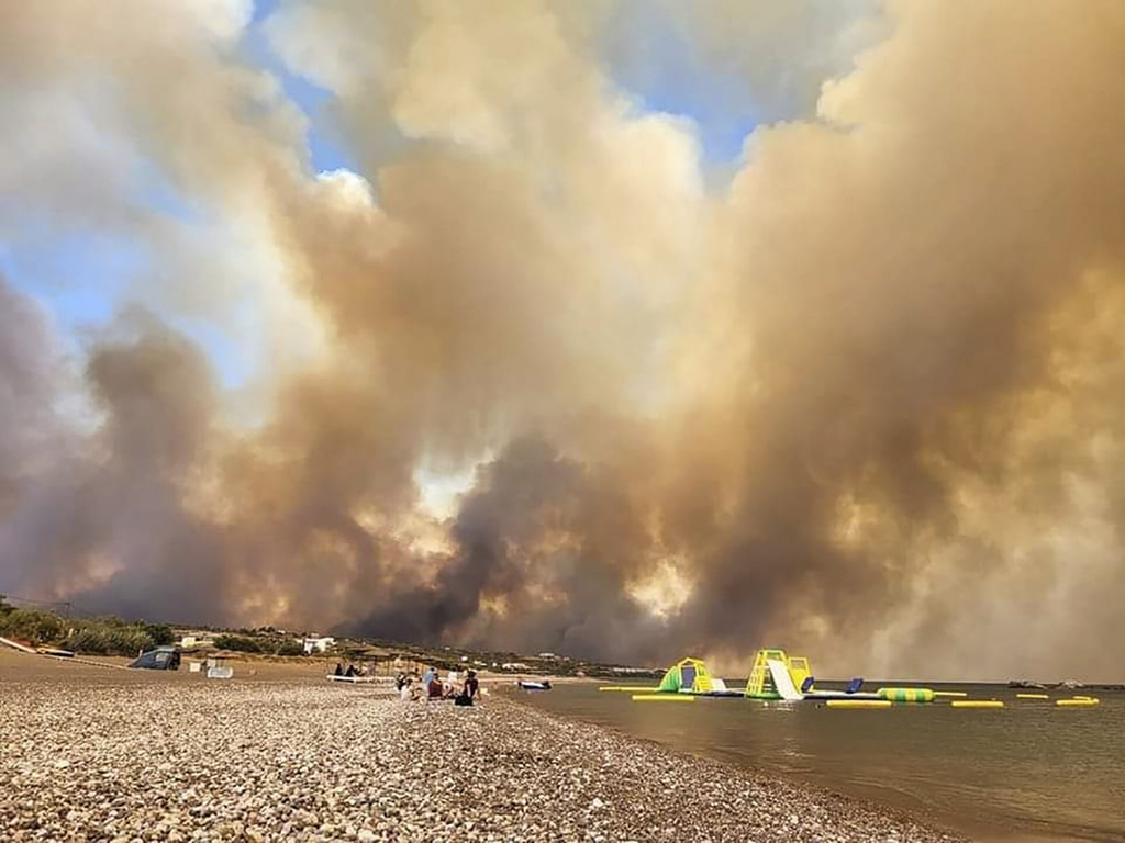 希臘羅德島山火肆虐，遊客沙灘等待救援。美聯社