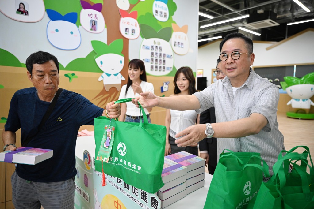 香港各界扶貧促進會常務副會長蔡榮星向街坊派月餅及禮品包。