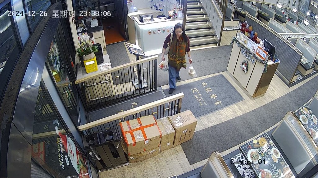 吳女士拿着兩袋食物離開餐廳。（涉事餐廳提供照片）