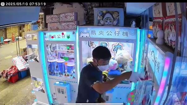 黑衫男向夾公仔機淋紅油。店主提供影片