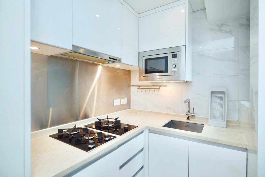 开放式厨房设洁白厨柜、嵌入式家电如雪柜等。