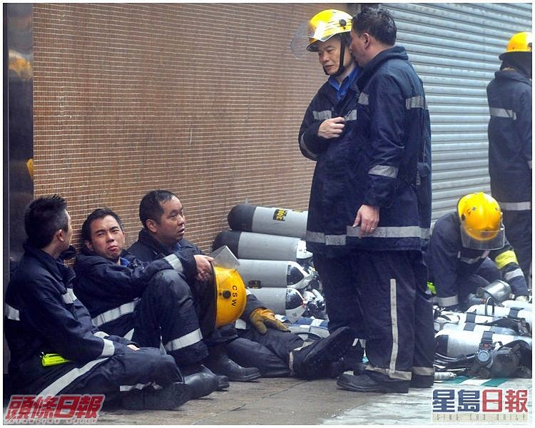 部分曾深入火場撲救消防員坐在地上休息。