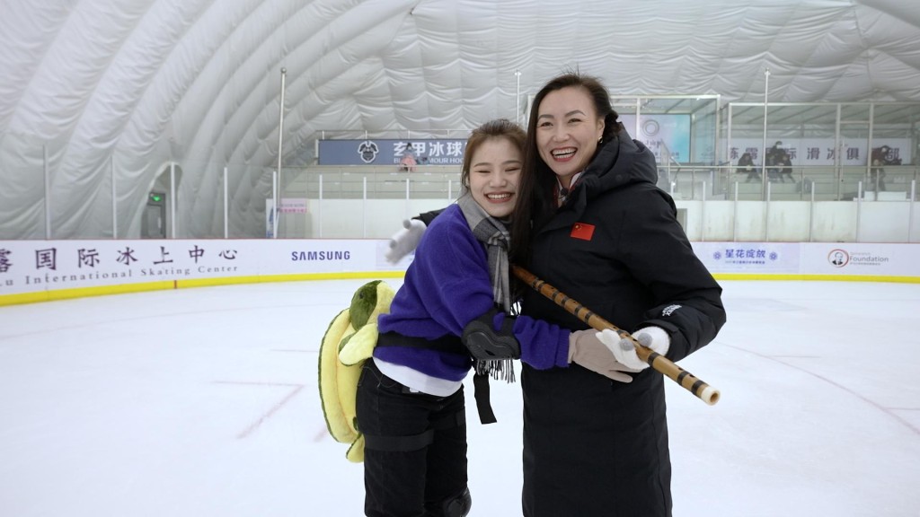 吴洛蕙(左)向陈露送上父亲亲手制作的笛子，更在冰场即席演奏《梁祝》。特区政府驻京办提供图片