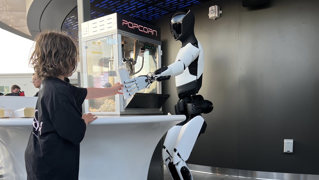 特斯拉自家研發Optimus人型機械人「上班」派爆谷。 路透社