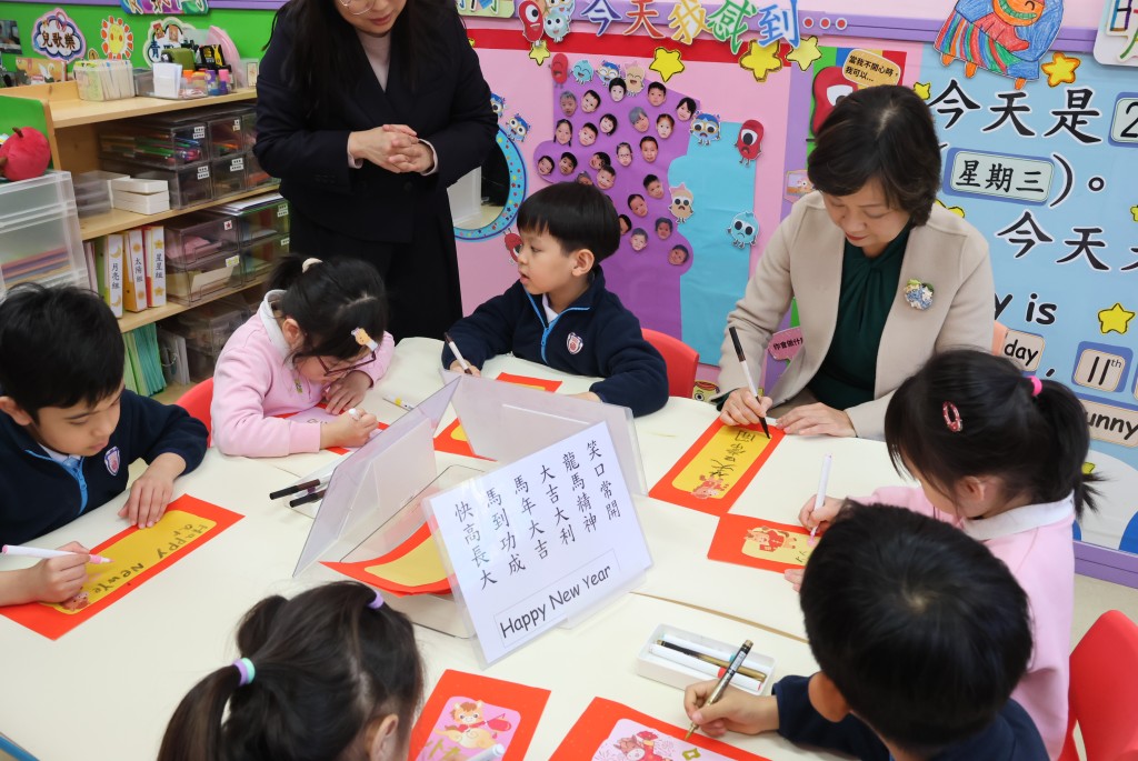 探訪期間蔡若蓮即席提筆，與學生們一同寫揮春。教育局提供