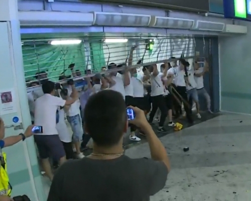 白衣人扯開港鐵車站鐵閘。港台影片截圖