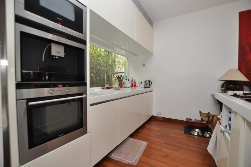 廚房設有多組白色廚櫃，收納空間亦充裕。
