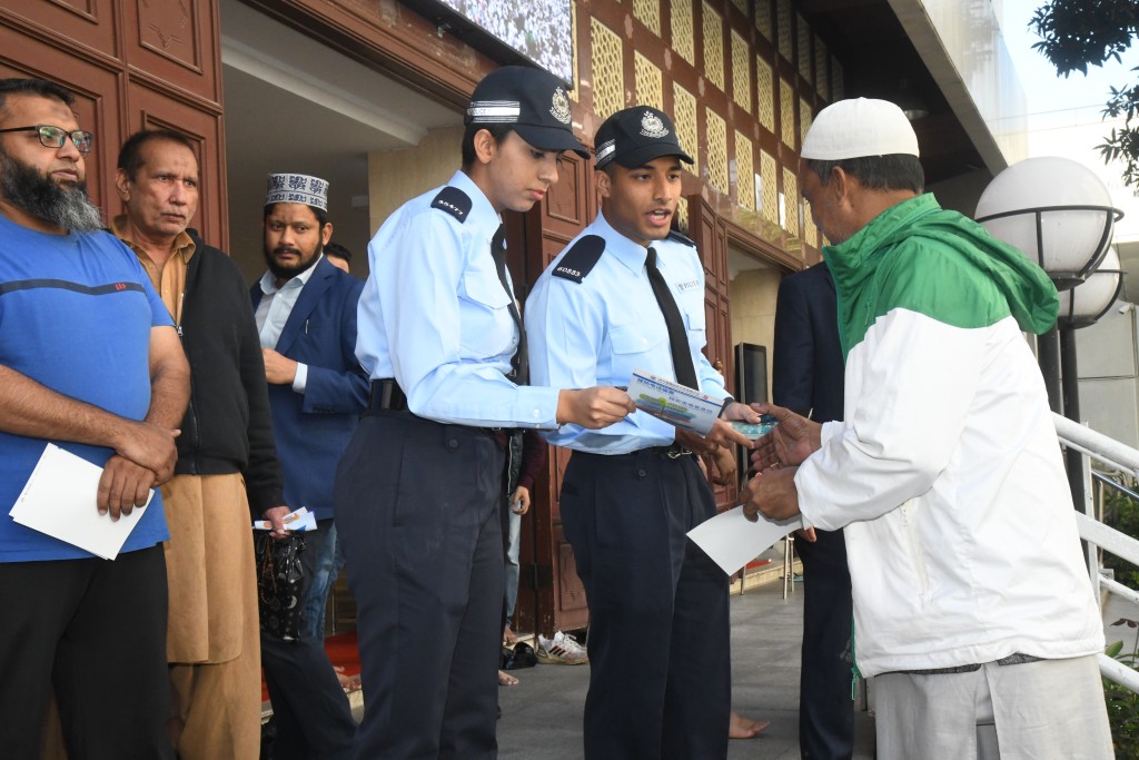 巴基斯坦籍警員莎瑪和阿南文在清真寺門外向信徒派發防騙宣傳單張。 徐裕民攝