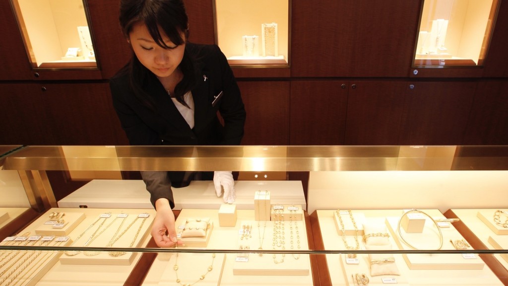 東京銀座一間金飾店職員正在整理飾櫃。 路透社