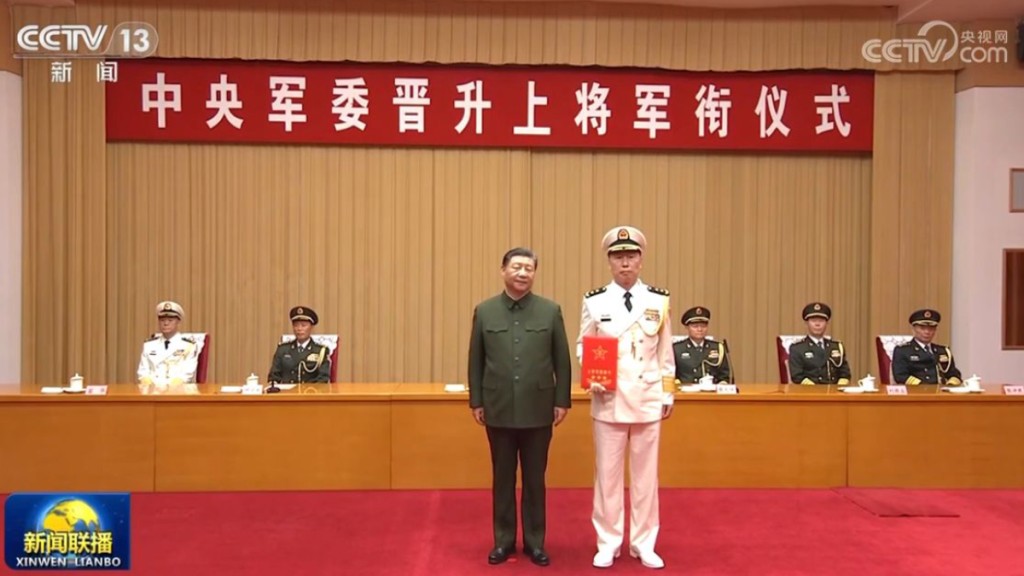 海军司令员胡中明晋升为上将，中央军委主席习近平颁发命令状。(央视截图)