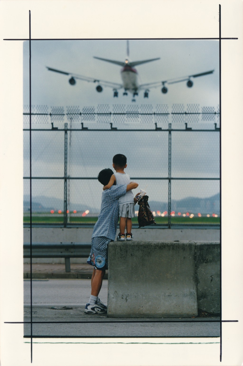1998年啟德機場關閉前市民爭取機會在場外近距離觀看飛機降落。資料圖片