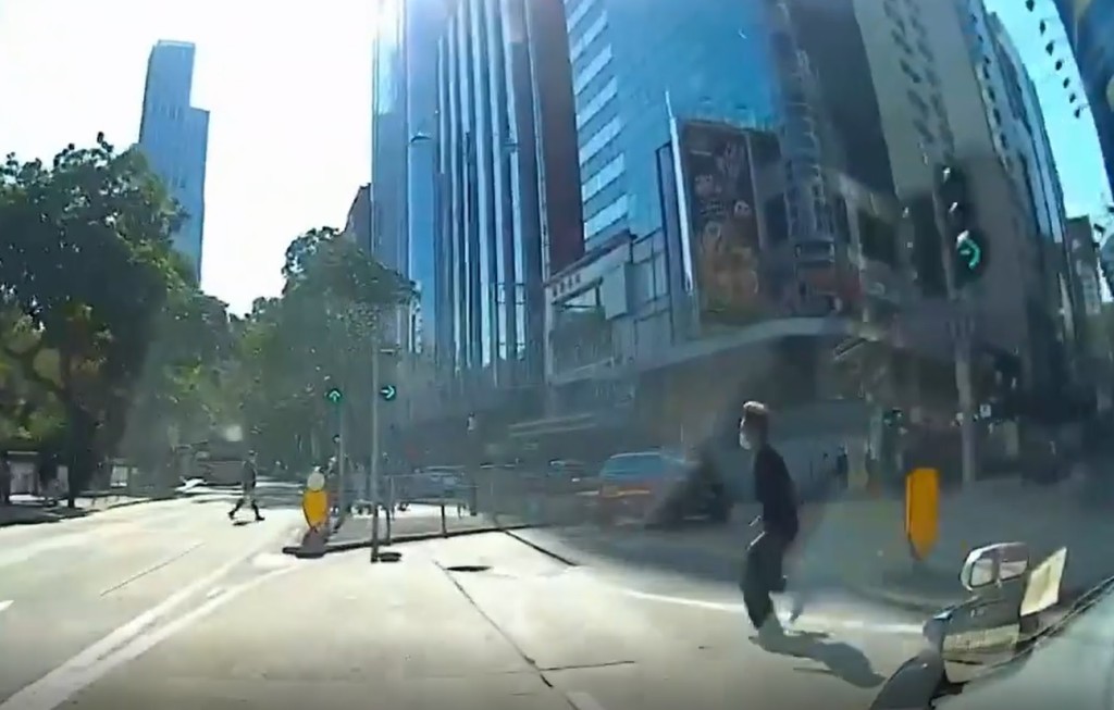 男途人越過轉入金馬倫道的兩線行車路時，的士司機連忙慢車。（影片截圖）