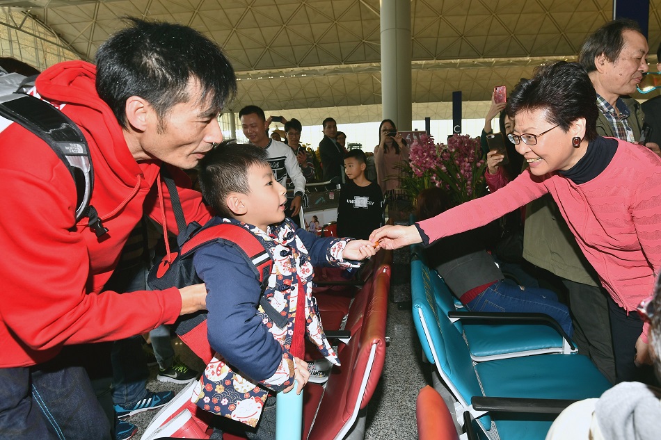 林鄭月娥在機場向市民及旅客拜年,並派朱古力及合照。新聞處