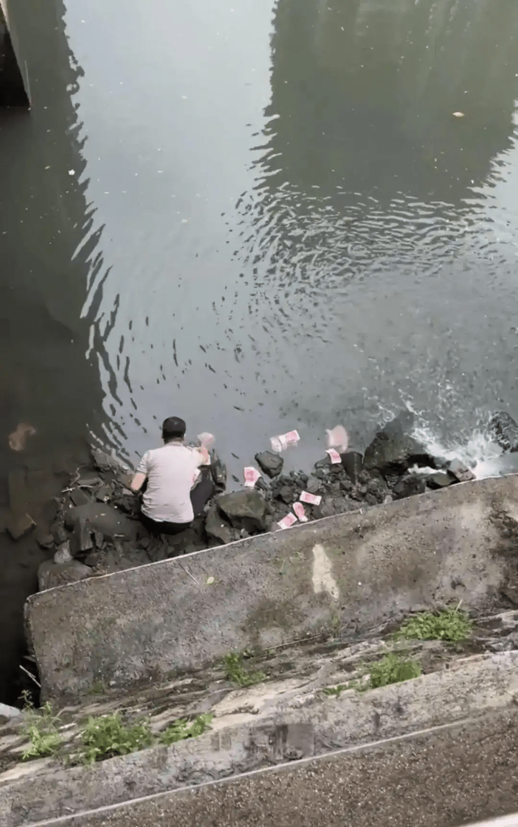 男子河道撿走河道中的現金。 男子河道撿走河道中的現金。