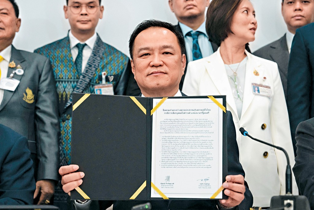 自豪泰黨魁阿努廷展示與人民黨簽署的合作協議。