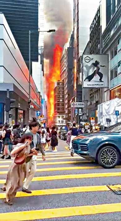 大廈陷入火海,黑煙沖天,不少途人見狀爭相走避。