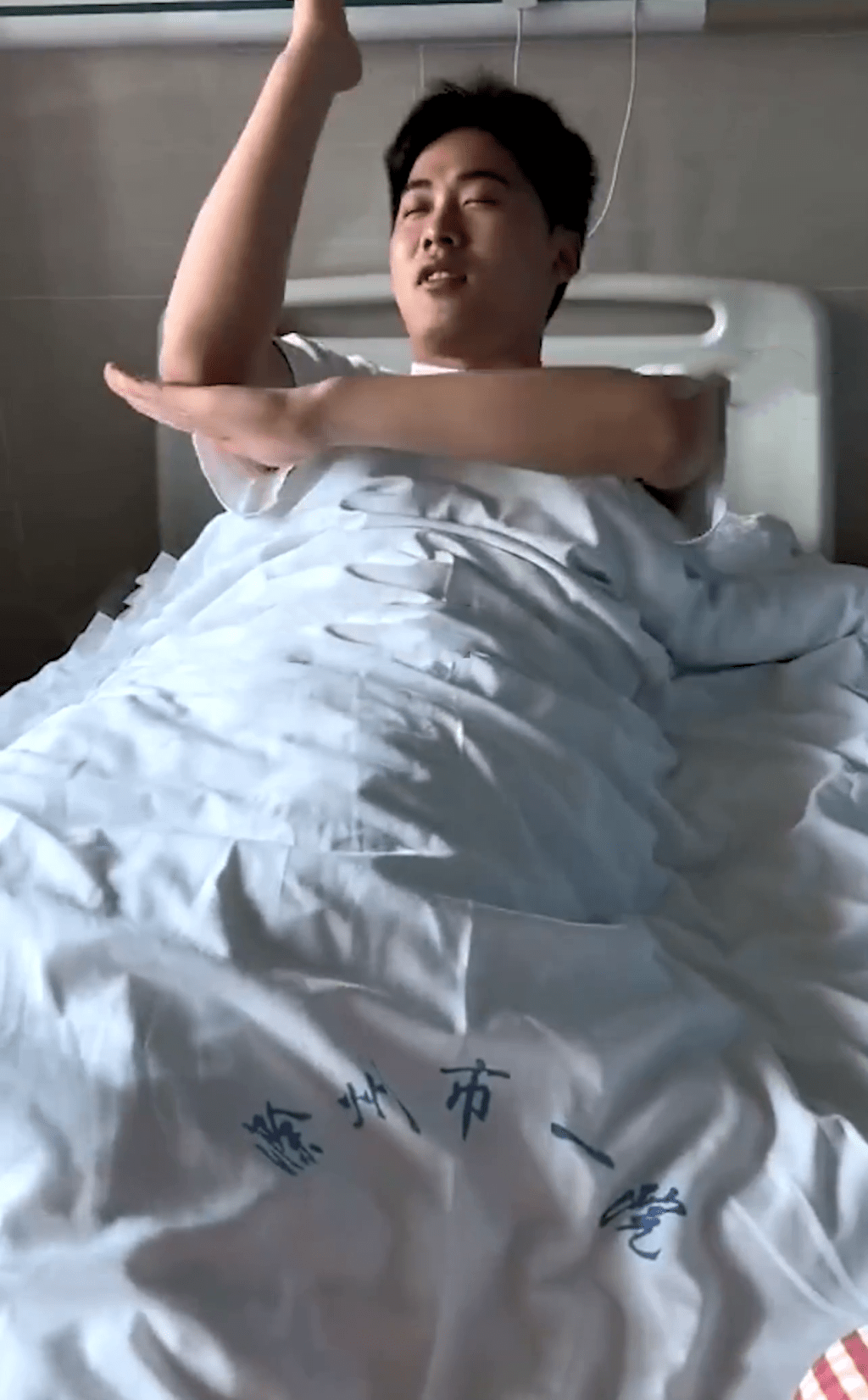 影片顯示，辛男在醫院病床上模仿鹹蛋超人射死光的動作。網片截圖