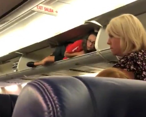 西南航空乘客登机时，发现座位上方行李架内有一位空姐。（网图）