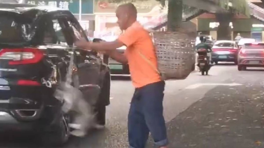 四川街頭有中年漢疑為碰瓷，將小狗掟向汽車車頭。微博