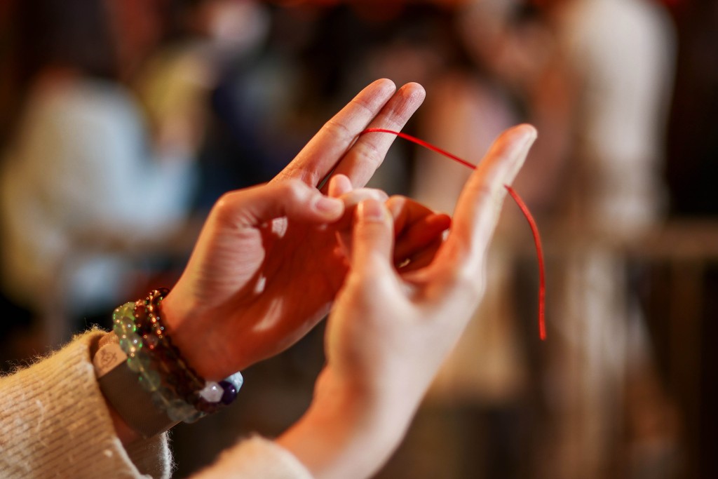 善信手持紅繩,以特定手勢參拜。 善信手持紅繩,以特定手勢參拜。