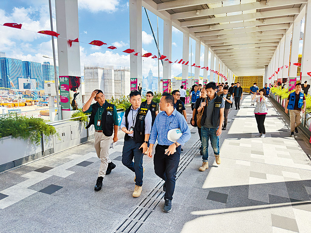 探員向港鐵安全主任(藍色恤衫)了解情況。