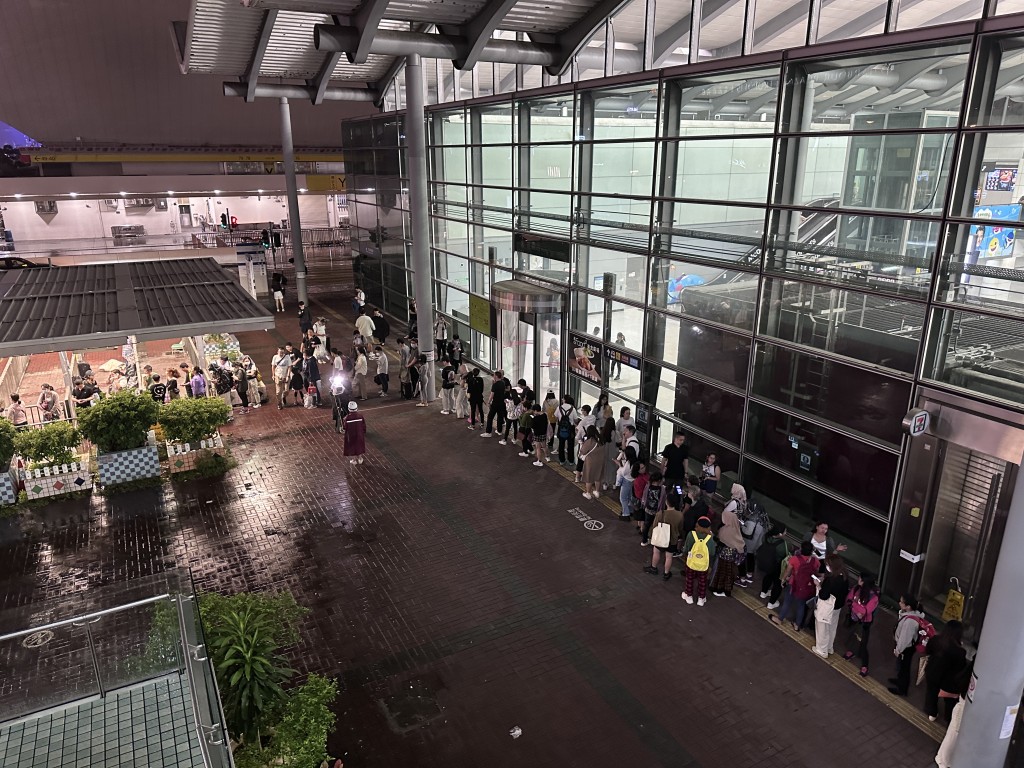 颱風小犬吹襲期間市面情況，有市民在鐵路站排長龍等待的士。（蘇正謙攝）