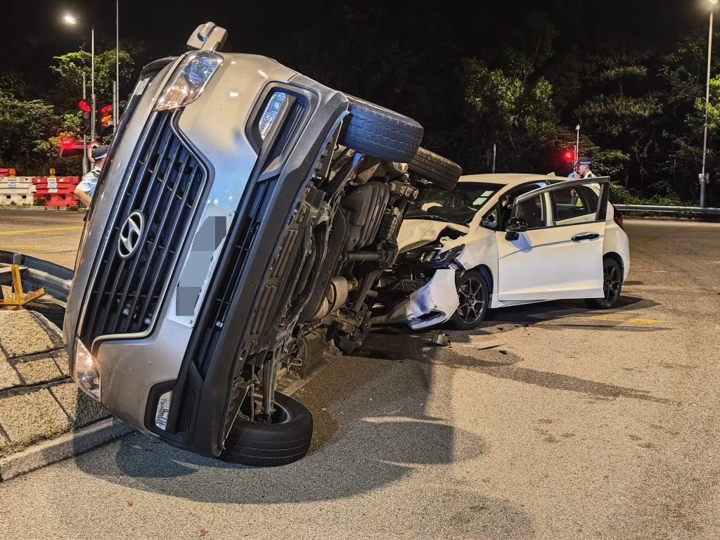 貨客車與私家車相撞後向右翻側。 貨客車與私家車相撞後向右翻側。