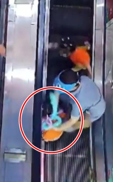 小女兒跌向扶手電梯旁（紅圈示）。網上截圖