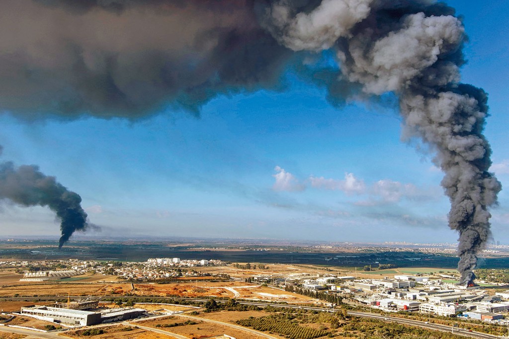 以色列中部雷霍沃特市的建築物被哈馬斯發射的火箭彈擊中，冒出濃煙。