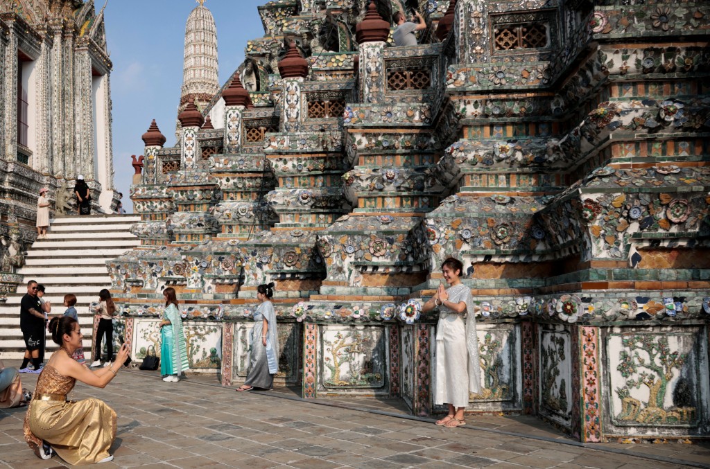 遊客穿着泰國傳統服飾在曼谷黎明寺留影。 路透社