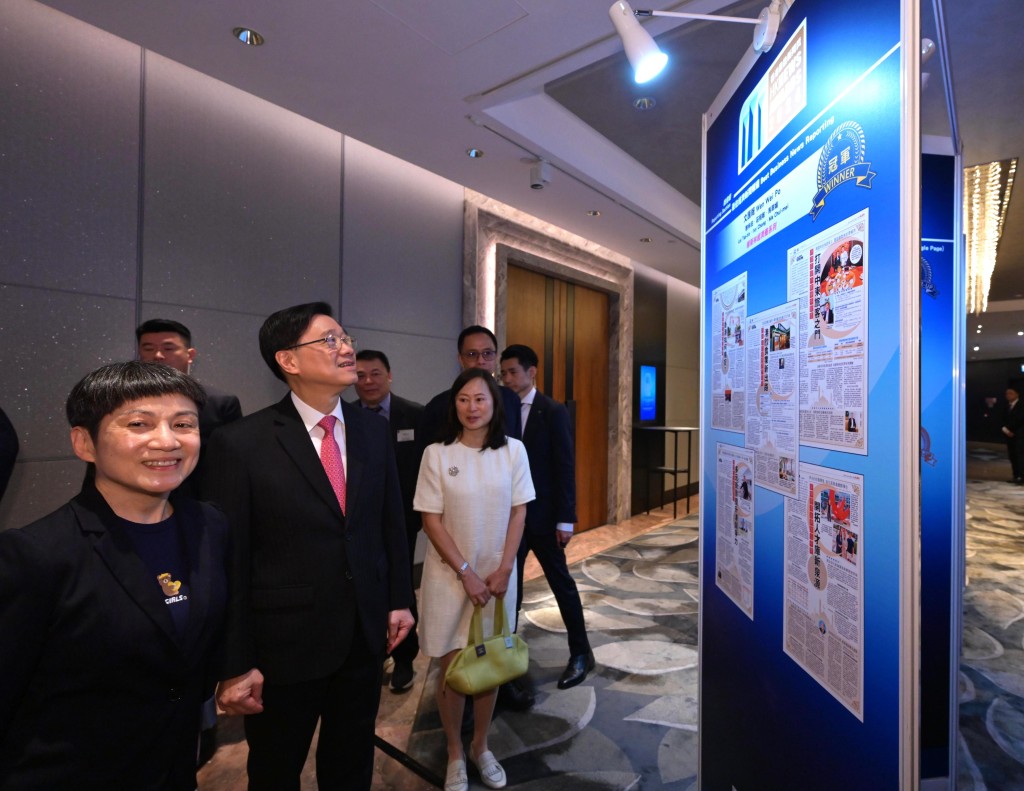 李家超(左二)在香港報業公會主席郭艷明(左一)陪同下參觀展板。政府新聞處 李家超(左二)在香港報業公會主席郭艷明(左一)陪同下參觀展板。政府新聞處