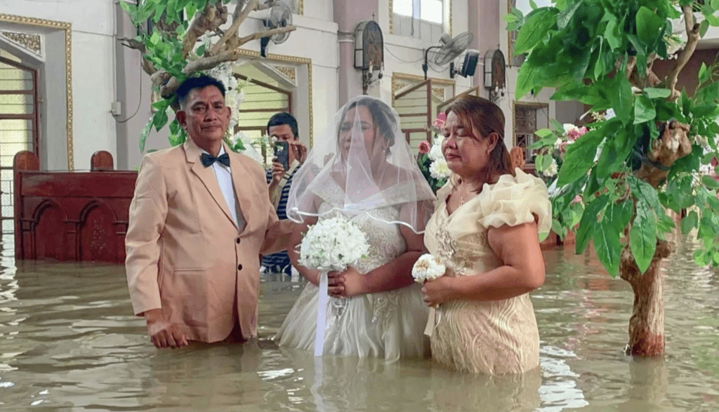 新人、家人及賓客全部站在洪水中見證婚禮。法新社 新人、家人及賓客全部站在洪水中見證婚禮。法新社