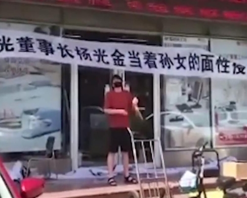 男子拉起橫額敲鑼怒喊父親喪盡天良。網圖