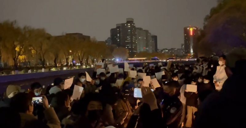 北京市民昨深夜聚集在亮马河，手持白纸表达抗议。网图