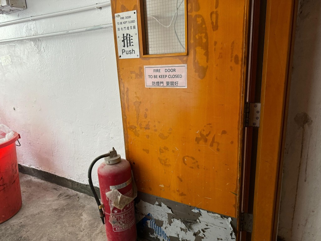 不少防烟门开启，多数放置了过期的旧灭火筒阻碍关门。  麦键泷摄