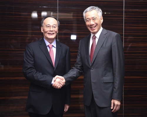 王岐山（左）访问新加坡，与李显龙会晤。新华社
