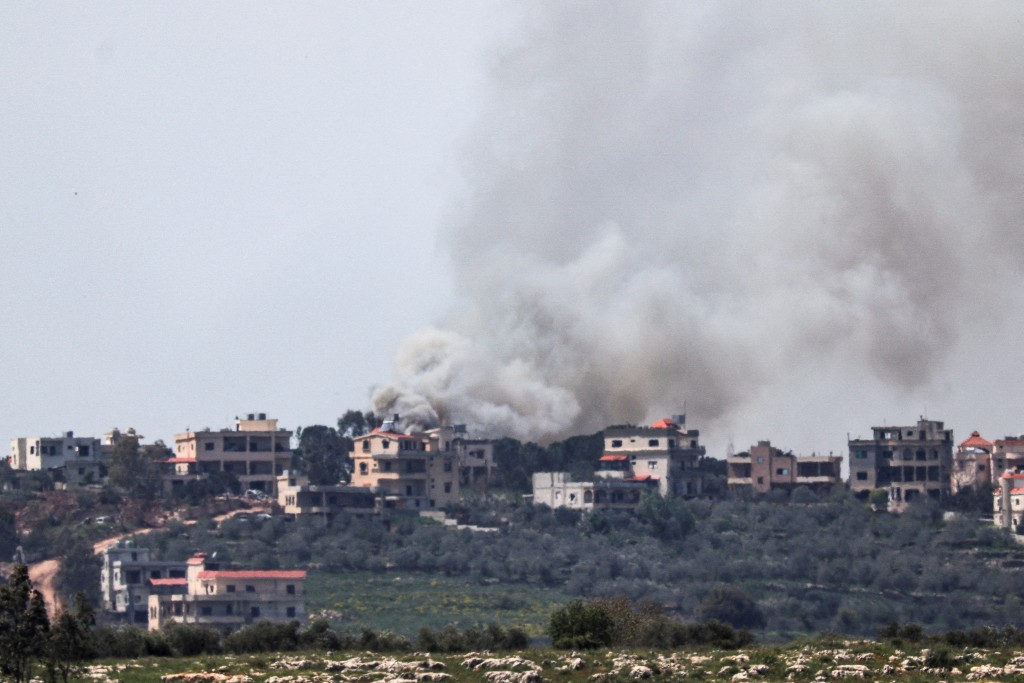 4月14日，从以色列北部边境的以色列一侧拍摄的画面显示，以色列空袭黎巴嫩南部靠近以黎边境地区后，浓烟升起。路透