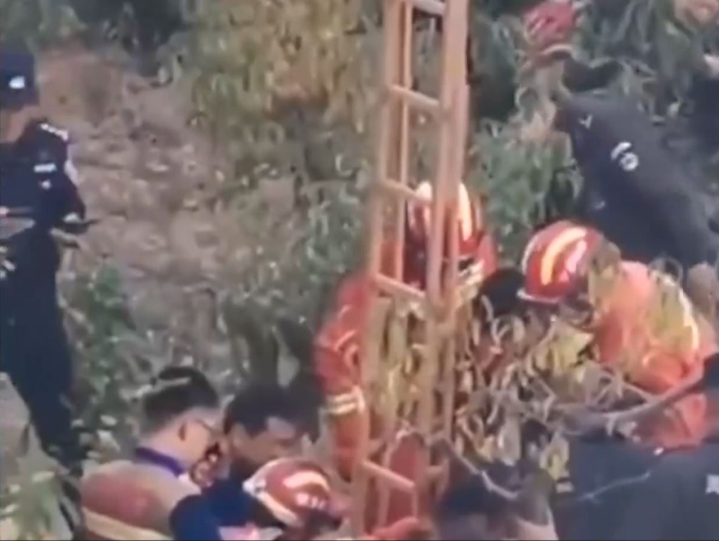 救援人員在現場將落井的2名成人救出。影片截圖