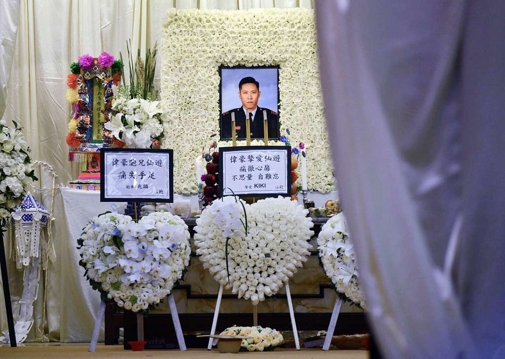 靈堂擺滿白花，何偉豪遺照前是摯親的花牌。