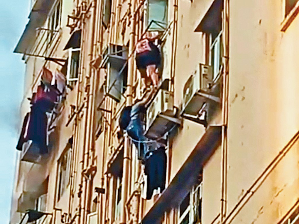兩人爬出外牆，沿下一層窗戶進入單位逃生。 
