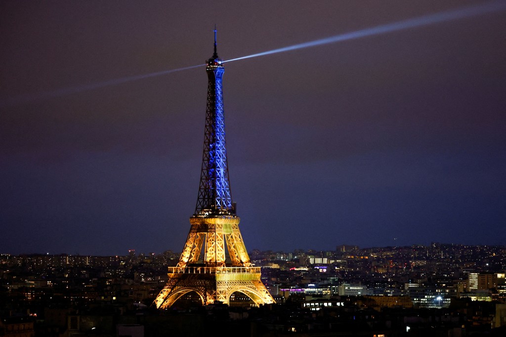 在巴黎，著名地标巴黎铁塔被打上蓝色与黄色灯光。路透社