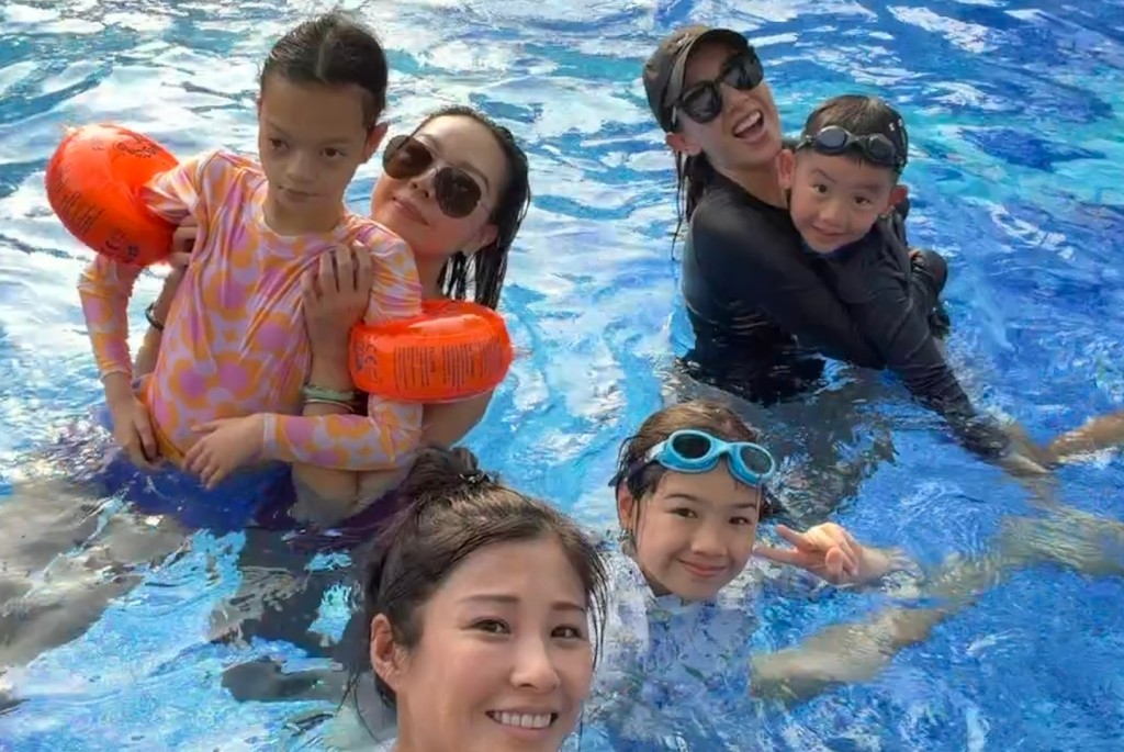 鍾麗淇抱著行動不便的長女，在泳池嬉水消暑。